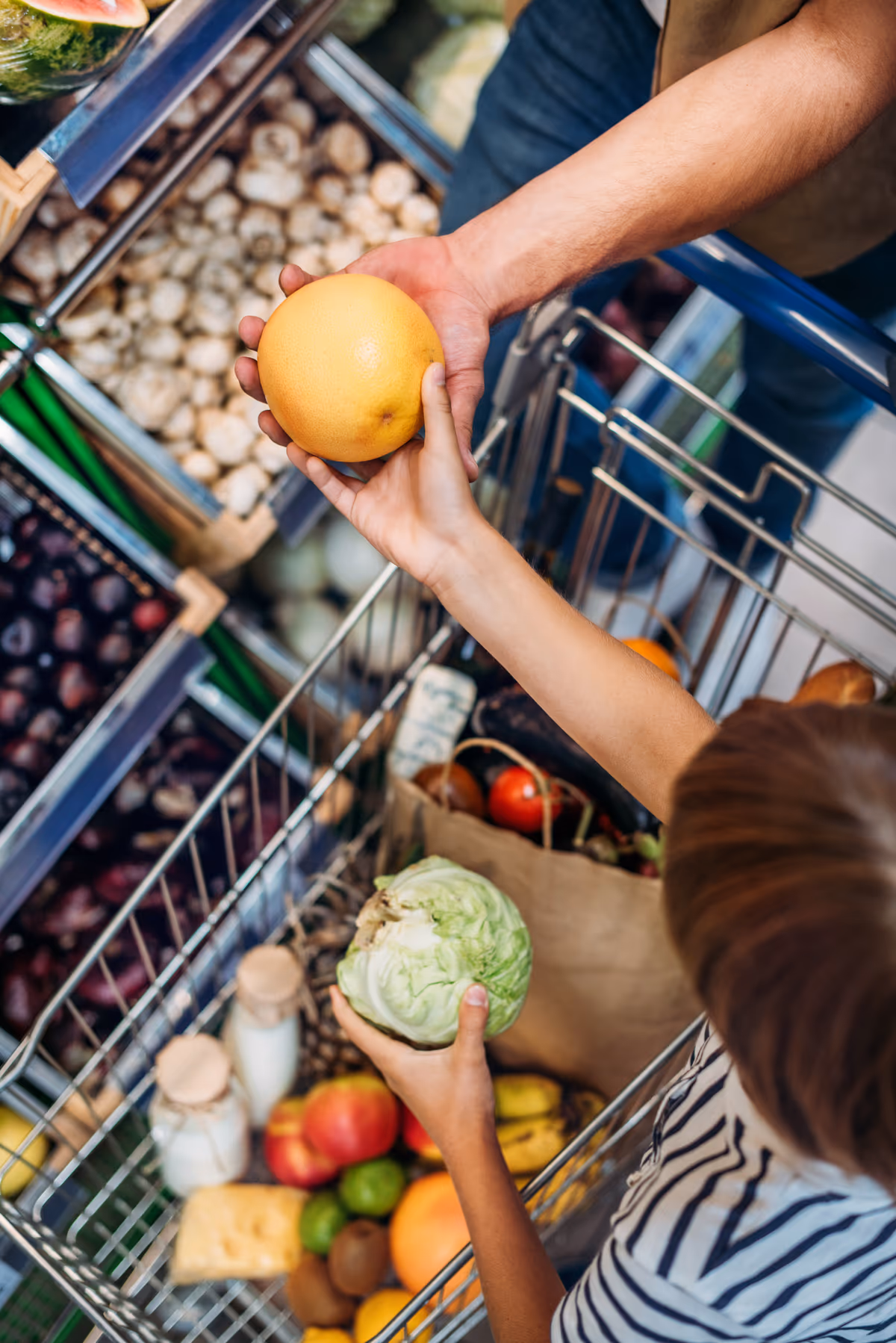 Child helping a parent compare groceries in a supermarket aisle